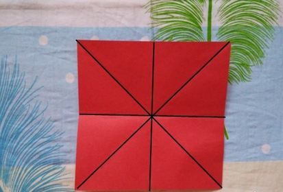 准备一张正方形彩纸，对角线折叠、上下对折、左右对折，出现米字型折痕。